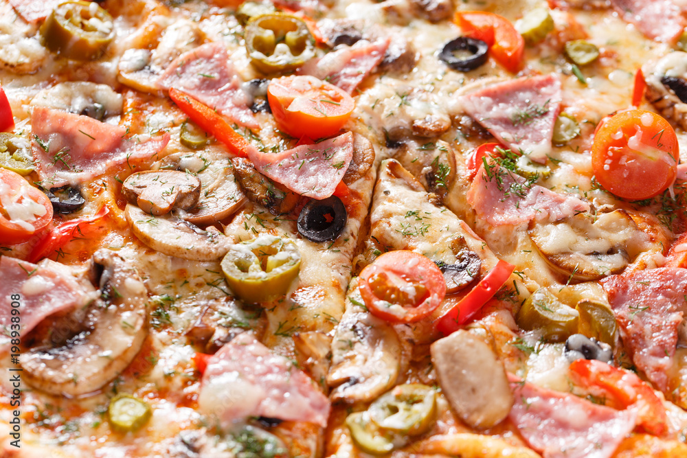 Italian kitchen and cooking concept. Hot tasty sliced with ham, sausage, jalapenos, mushrooms, tomato. Eat delivery concept. Italian kitchen and cooking concept. Hot tasty sliced with ham, sausage, jalapenos, mushrooms, tomato. Eat delivery concept.