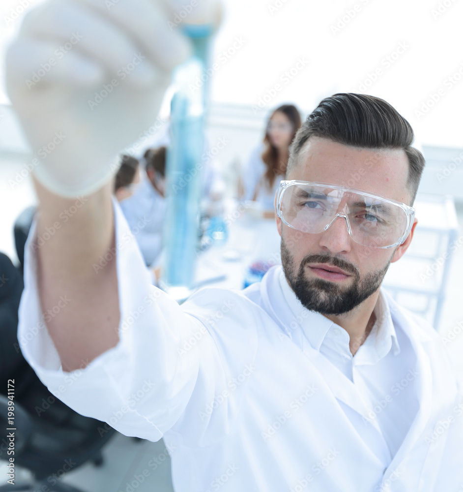 image is blurred. young scientist holding tube with the reagents image is blurred. young scientist holding tube with the reagents