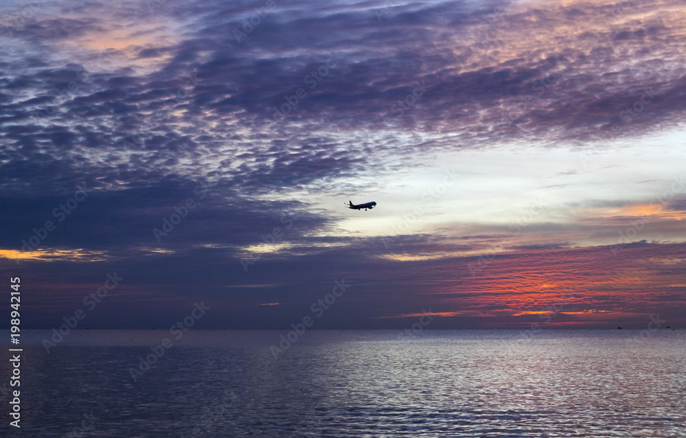 Silhouette of airplane flying over sea at the amazing sunset Silhouette of airplane flying over sea at the amazing sunset