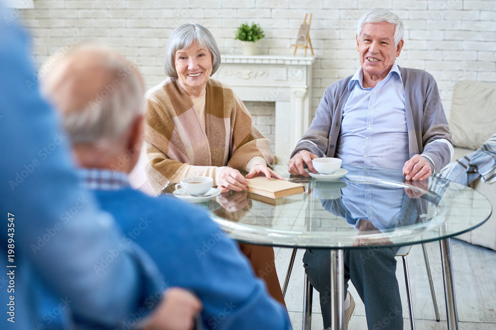 Portrait of several senior people enjoying free time in retirement home, one of them in wheelchair, copy space