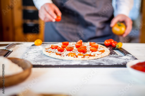 closeup hands of chef making fresh homemade traditional italian pizza. wallpaper for pizzeria and cooking food concept