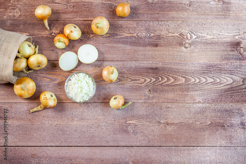 fresh onions on a wooden table background with copy space for text. wallpaper for grocery shopping and cooking food concept. top view, flat lay