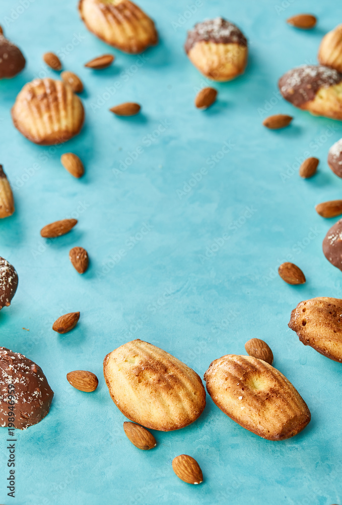 Yummy almond cookies arranged on blue background, close-up, selective focus, top view. Yummy almond cookies arranged on blue background, close-up, selective focus, top view.