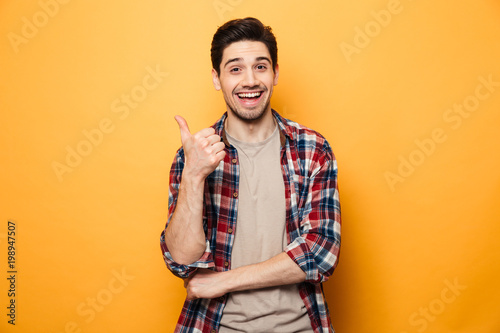 Portrait of a smiling young man pointing finger away