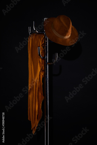 scarf and hat hanging on coat rack isolated on black