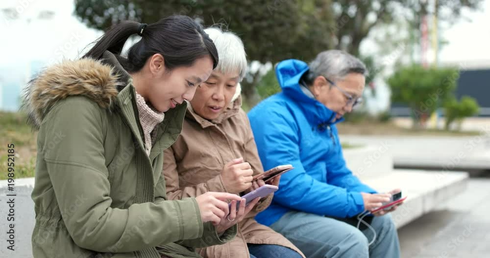 Asian Family using mobile phone in the street Asian Family using mobile phone in the street