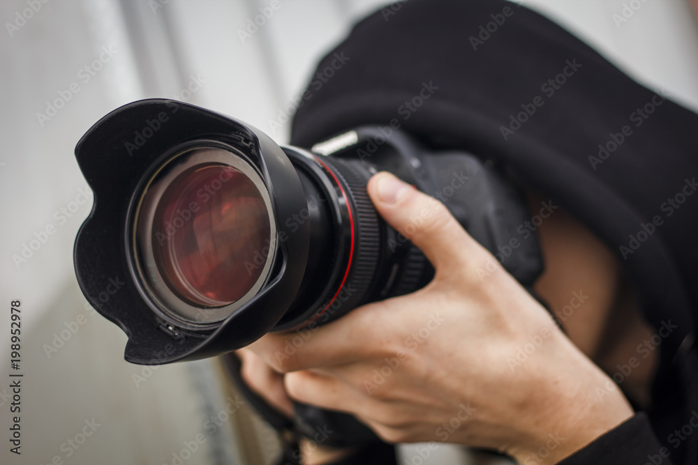 Young man, paparazzi, taking pictures on the street