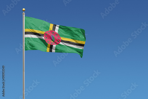 Flag of Dominica in front of a clear blue sky