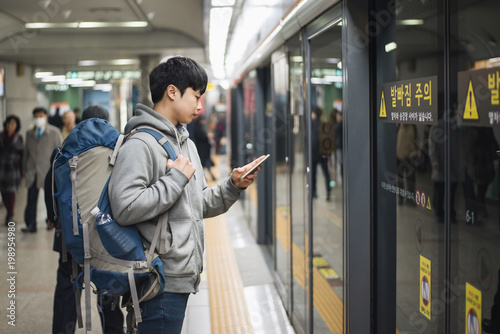 Young man traveling to Korea, male waiting for subway