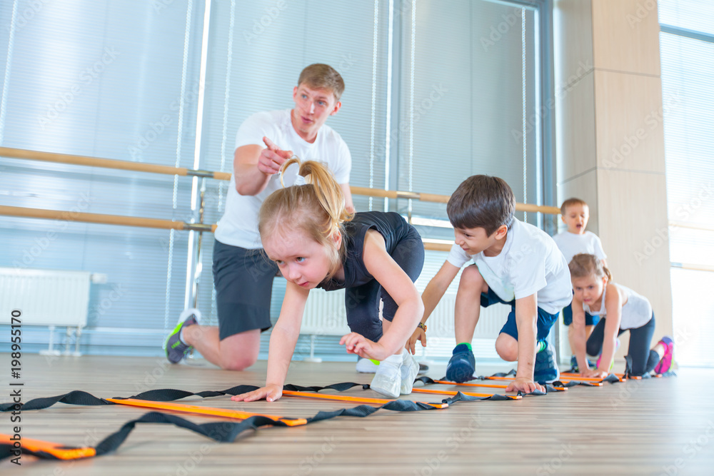 Fototapeta premium Happy sporty children in gym. Kids exercises