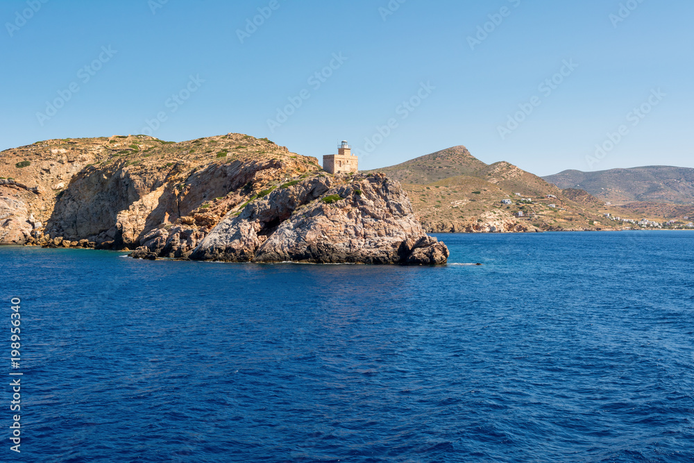 The lighthouse harbor on rocks by sea on Ios island. Greece.