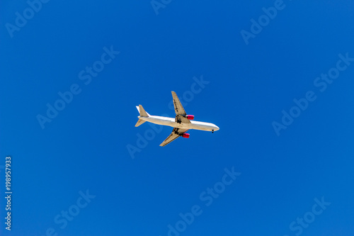 A plane flying in the blue sky without white clouds