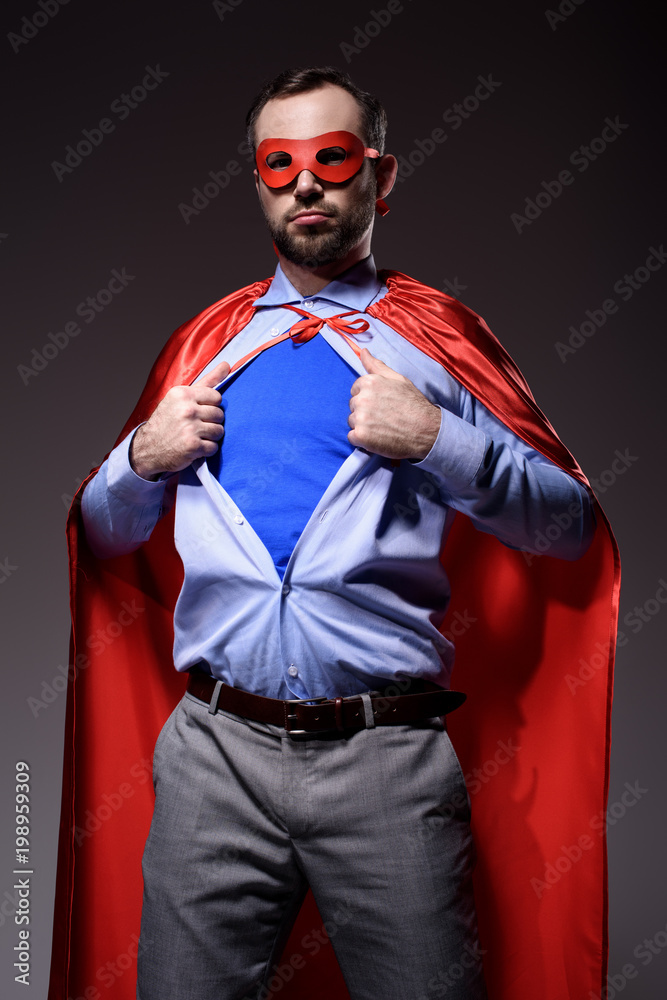 handsome super businessman in mask and cape showing blue shirt isolated on black handsome super businessman in mask and cape showing blue shirt isolated on black