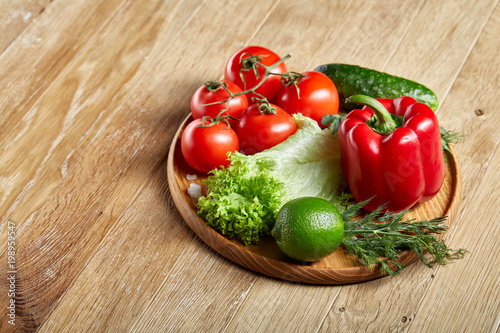 Artistic still life of assorted fresh vegetables and herbs on rustic wooden background, top view, selective focus.