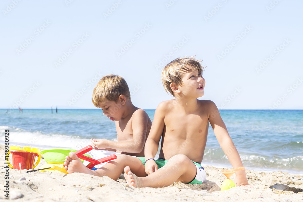 Boys playing in sand at beach Boys playing in sand at beach