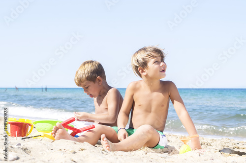 Boys playing in sand at beach © nellas