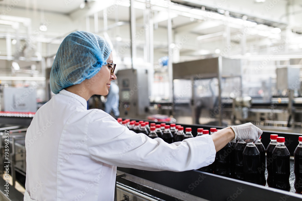 Woman Quality Control Serious middle age woman quality control worker checking robotic line ...