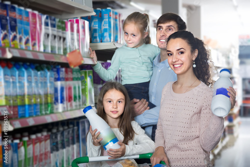 young parents with two kids holding purchases in store