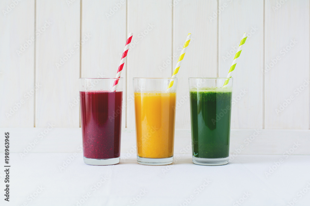Detox drinks in glass: fresh smoothies from vegetables: beet, pumpkin and spinach on white background Detox drinks in glass: fresh smoothies from vegetables: beet, pumpkin and spinach on white background