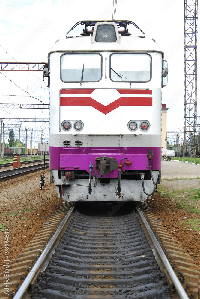Naklejka premium Electric locomotive of white color stands on rails