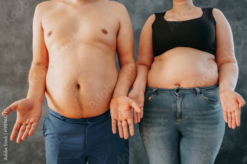 Overweight couple in perplexity, bewildered. Dieting, weight losing and health care concept
