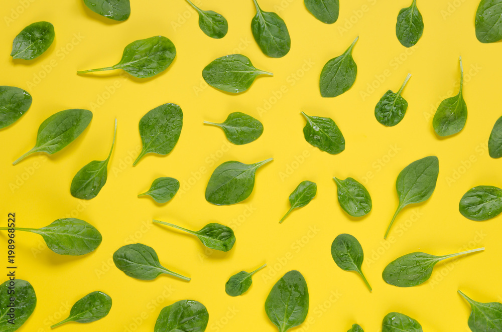 Spinach leaves pattern on yellow background.
