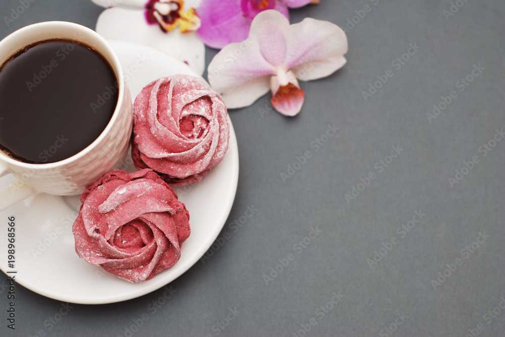 Sweet Pink Meringues and Cup of Coffee on Blue Gray background with Orchid Flowers. Spring Background with copy space. Breakfast. Sweet Pink Meringues and Cup of Coffee on Blue Gray background with Orchid Flowers. Spring Background with copy space. Breakfast.