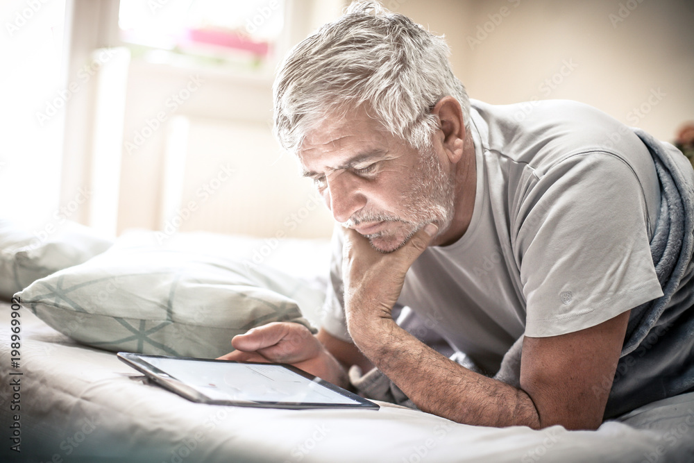 Using digital tablet in bed. Using digital tablet in bed.