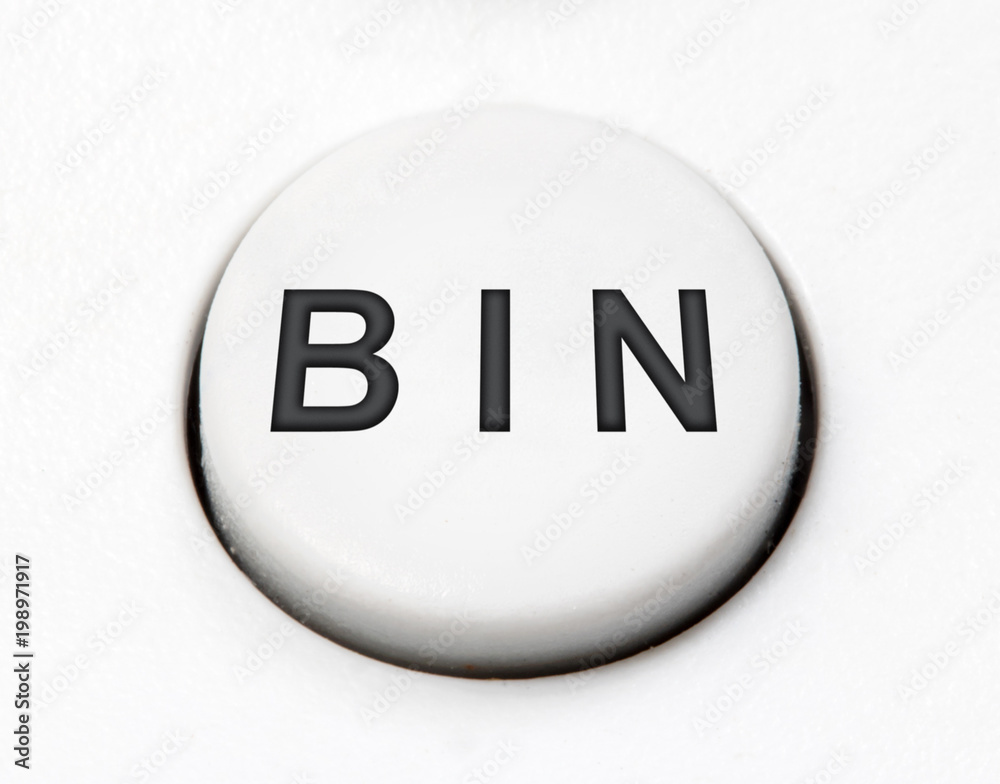 A white round button switch - bin, close up. Control mechanical key for delete on control device. A white round button switch - bin, close up. Control mechanical key for delete on control device.