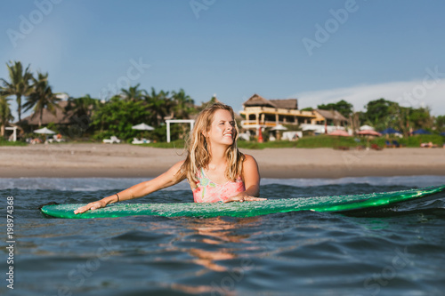 portrait of young woman in swimming suit with surfing board in ocean © LIGHTFIELD STUDIOS
