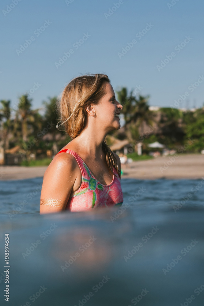 side view of smiling young woman looking away in ocean