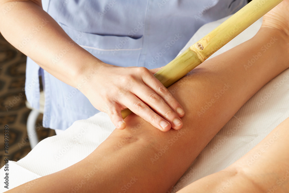 Fototapeta premium Woman having bamboo stick massage at day spa