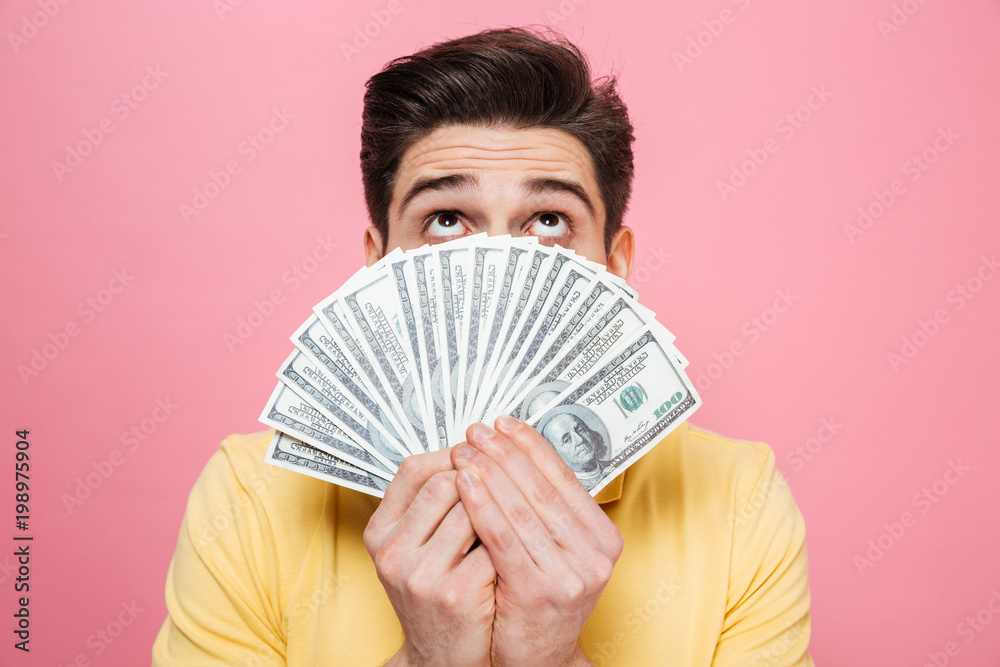 Portrait of a young man showing money banknotes Portrait of a young man showing money banknotes