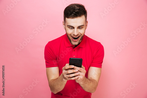 Portrait of a happy young man using mobile phone © Drobot Dean