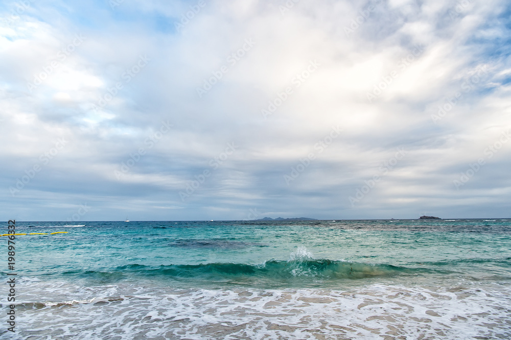 Sea waves on cloudy sky in philipsburg, sint maarten. Seascape and sky with clouds, white cloudscape. Beach vacation at Caribbean, wanderlust. Freedom, perspective and future.