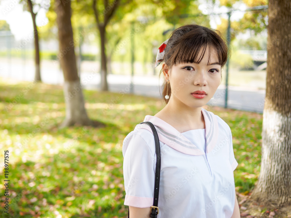 Portrait of beautiful Asian girl student in school uniform japanese style, looks a little sad and with tears in eyes. Portrait of beautiful Asian girl student in school uniform japanese style, looks a little sad and with tears in eyes.