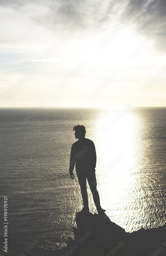 man observes the sea at sunset from high place man observes the sea at sunset from high place