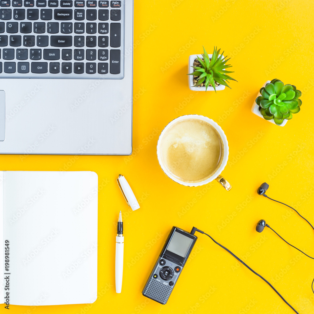 Φωτογραφία The workplace of the journalist is a laptop, a dictaphone, headphones, a notebook, a pen and green plants on a yellow background