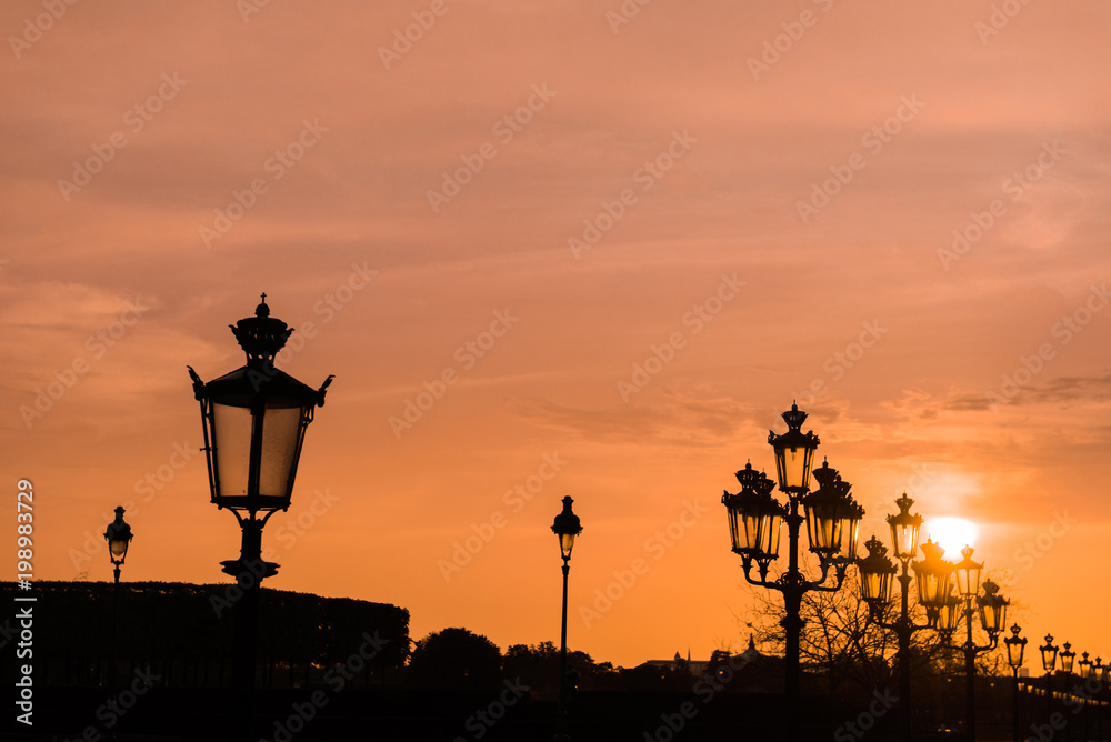 Sunset in Paris with silhouette of the luminaries