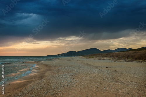 The coast of the Greek island in stormy weather. It's raining on the horizon