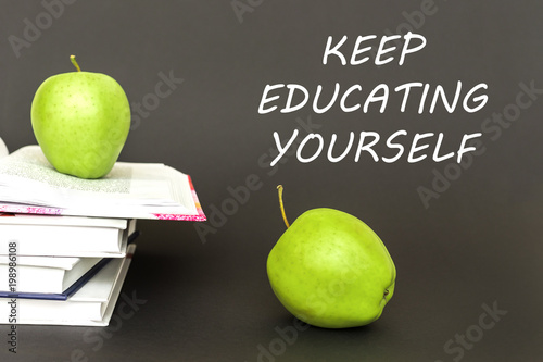 Εκτύπωση καμβά text keep educating yourself, two green apples, open books with concept