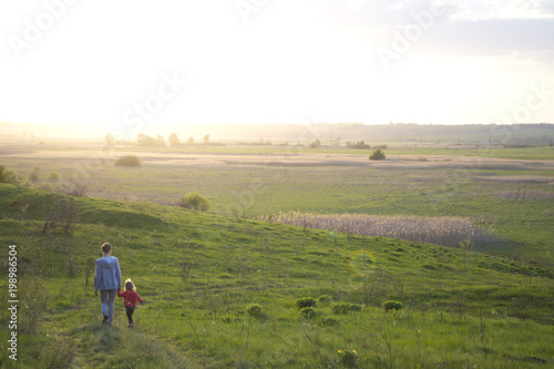 Ukraine. End of april. Sunset: field and mom with daughter. 