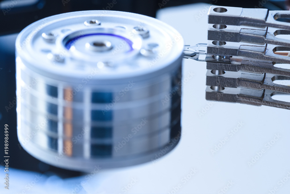 Disassembled hard disk drive inside close-up, spindle, actuator arm, read write head, platter Disassembled hard disk drive inside close-up, spindle, actuator arm, read write head, platter