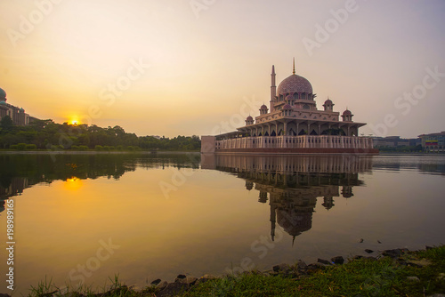 Mirror reflection of beautiful Putra Mosque in the lake during sunrise.