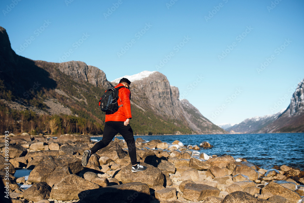 Man jump on the rocks alone at fjord in Norway, Travel lifestyle emotions vacations outdoor, scandinavian nature Man jump on the rocks alone at fjord in Norway, Travel lifestyle emotions vacations outdoor, scandinavian nature