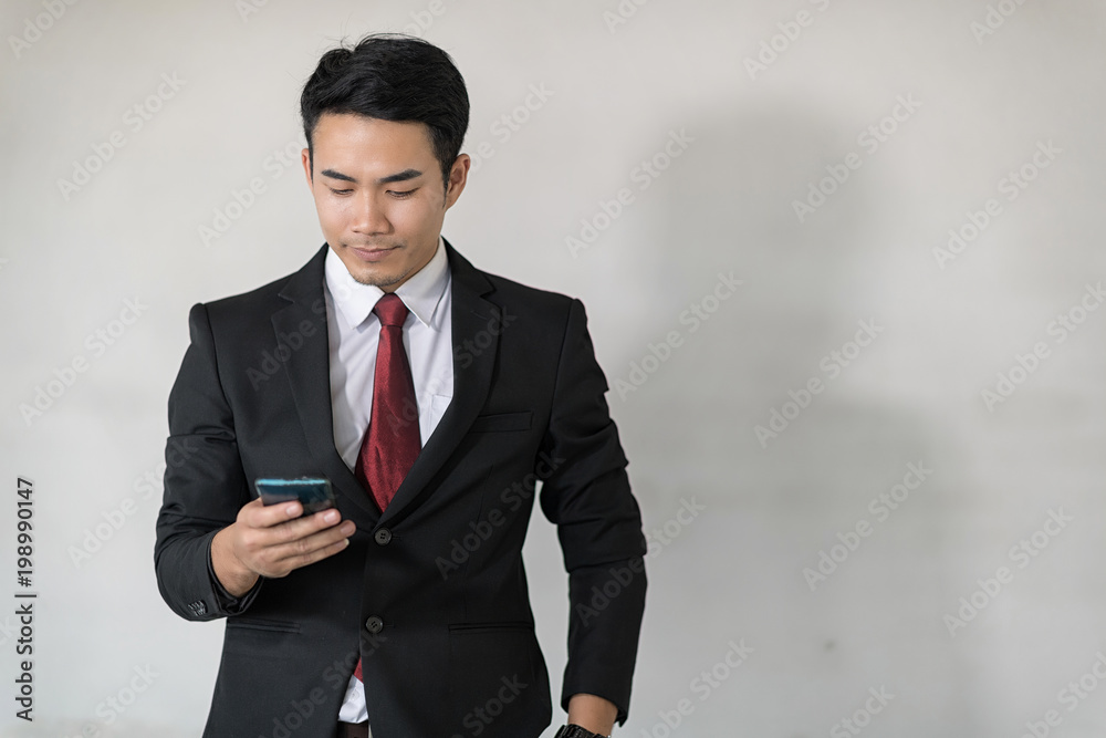 Young handsome Asian businessman using mobile phone. Young handsome Asian businessman using mobile phone.