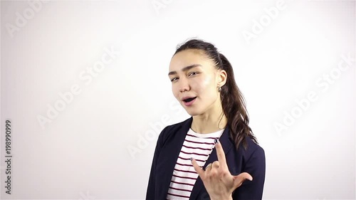 A beautiful young girl gestures by shows heavy metal gesture.