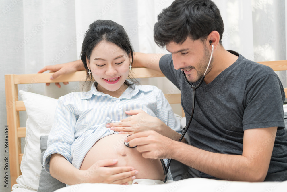 In Selective Focus Of Happy Family Checking New Baby In The Morning.Close Up Of A Beautiful Happy Pregnant Woman With Big Belly. Pregnancy And Motherhood Moment People And Expectation Concept. In Selective Focus Of Happy Family Checking New Baby In The Morning.Close Up Of A Beautiful Happy Pregnant Woman With Big Belly. Pregnancy And Motherhood Moment People And Expectation Concept.