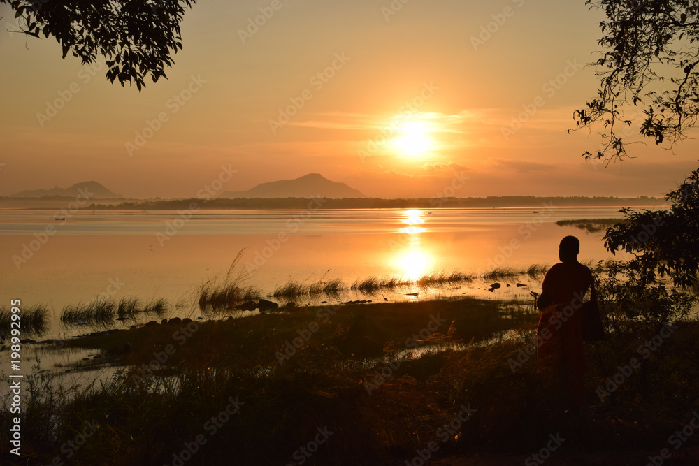 Sunrise on Nuwara Wewa (with meditating monk), Sri Lanka