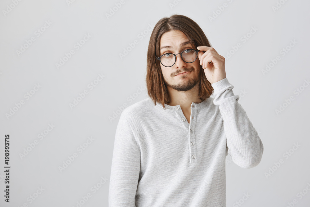 Indifferent smart snob did not care Portrait of european guy in glasses standing with gloomy being focused and uninterested in discussion, getting back to work Stock Photo
